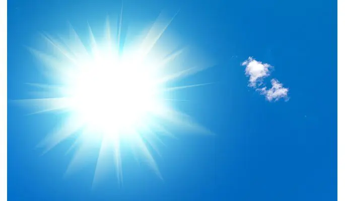 A bright sun shining in the blue sky.